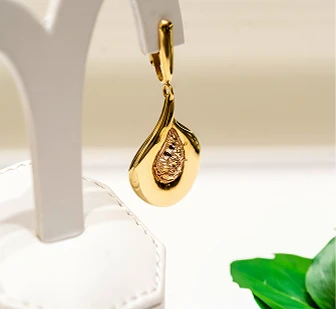 Arete dorado elegante en exhibidor para casa de empeño