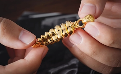 Persona sosteniendo una joya de oro para empeñar en casa de empeño